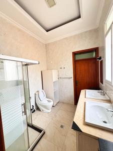 a bathroom with a toilet and a sink at Family Corner Suite by Iwacu Stays in Kigali