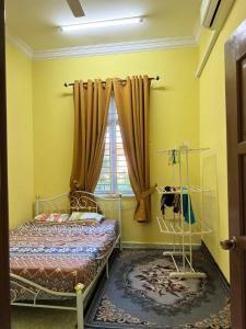 a bedroom with a bed and a window at HB Warisan Homestay in Kota Bharu