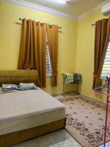 a bedroom with a bed and a window with curtains at HB Warisan Homestay in Kota Bharu
