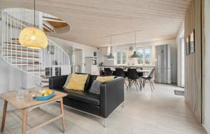 TåbelにあるPet Friendly Home In Vestervig With Saunaの黒いソファとテーブルのあるリビングルーム