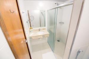 a bathroom with a sink and a glass shower at Hotel Dan Inn Uberaba & Convenções in Uberaba