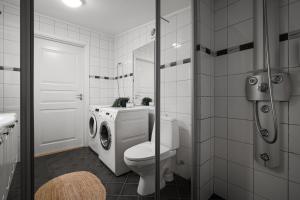 a bathroom with a toilet and a washing machine at Tromsø Terrace - Top floor apartment with amazing views in Tromsø +14 photos