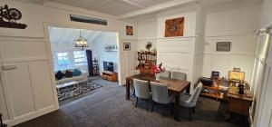 a living room with a desk and a table and chairs at Kiwi As Guest House in Rotorua