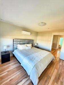 a large white bed in a bedroom with wooden floors at Your Halifax Getaway, Relax and Explore in Halifax
