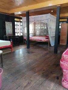 a room with two beds and a wooden floor at The Norsyah Villa selayar in Pareangang