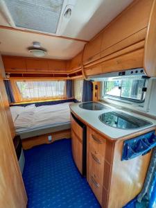 an interior of an rv with a sink and a bed at Къмпинг Alino Lake in Alino