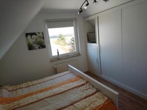 a bedroom with a bed and a window at Ostseewohnung Weiße Wiek in Hohenkirchen