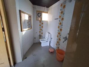 a small bathroom with a toilet and a window at Hotel Pandey Lodge By StayApart in Munsyari