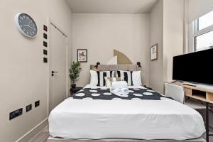 a bedroom with a large white bed and a desk at Beautifully Designed Studio with Communal Full Kitchen - Full Access in London