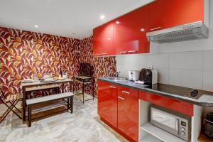 una cocina con armarios rojos y una mesa. en Bluestay 143 - Charming apartment in Asnieres, en Asnières-sur-Seine