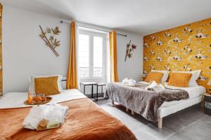 2 camas en una habitación con papel pintado de color amarillo en Bluestay 143 - Charming apartment in Asnieres, en Asnières-sur-Seine