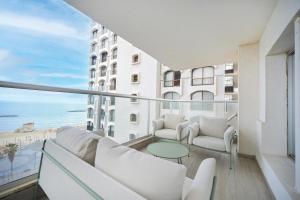 a balcony with white furniture and a view of the ocean at Orchid Hotel by HolyGuest in Tel Aviv +13 photos