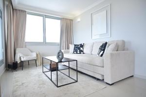 a living room with a couch and a table at Orchid Hotel by HolyGuest in Tel Aviv