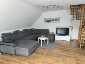 a living room with a couch and a tv at Ostseewohnung Weiße Wiek in Hohenkirchen