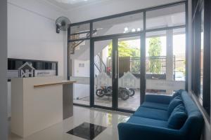 a living room with a blue couch in front of a window at RedDoorz Syariah near UNIMUS Semarang in Alastuwo