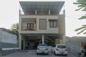 two cars parked in front of a house at RedDoorz Syariah near UNIMUS Semarang in Alastuwo
