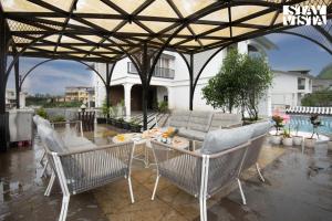 a patio with a table and chairs and a couch at StayVista at Solace Land with Bonfire, Jacuzzi in Lonavala