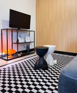 ein Zimmer mit Toilette und Fernseher auf einem karierten Boden in der Unterkunft Rosewood Stay Taguig Flat in Rosewood Pointe near BGC and the Airports in Manila