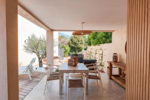 Un comedor con mesa y sillas en un patio. en Villa Luciana Di Santa Lucia, en Sainte-Lucie de Porto-Vecchio