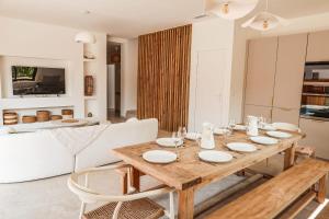 Un comedor con una mesa de madera y sillas blancas. en Villa Luciana Di Santa Lucia, en Sainte-Lucie de Porto-Vecchio