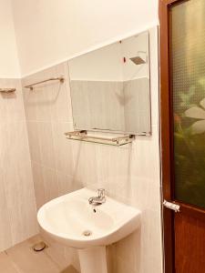 a bathroom with a sink and a mirror at Hotel Nimthera in Kuruwita