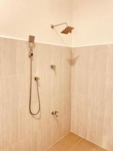 a shower with a shower head in a bathroom at Hotel Nimthera in Kuruwita +38 photos