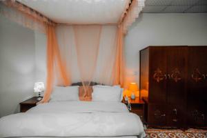 a bedroom with a large bed with an orange curtain at Mbeya Forest Hill Motel in Mbeya +25 photos