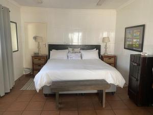 a bedroom with a large bed with white sheets and pillows at Karoo Huisie in Vanderbijlpark