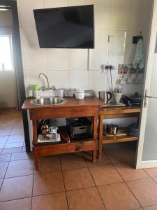 a kitchen counter with a sink and a tv on the wall at Karoo Huisie in Vanderbijlpark