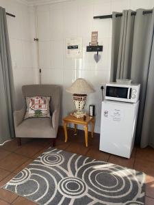 a living room with a chair and a microwave at Karoo Huisie in Vanderbijlpark