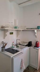 a white kitchen with a sink and a counter at Spice Suites-Rosemary in Amorgos +10 photos