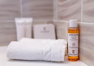 a bottle of hand sanitizer next to a pile of towels at Albergo Miramare Positano in Positano +88 photos