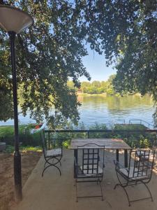 a table and chairs with a view of a lake at Vikendica na Tisi in Ada