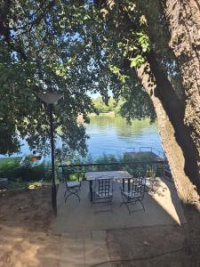 a table and chairs with a view of a lake at Vikendica na Tisi in Ada