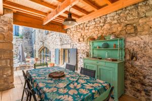 une salle à manger avec une table et un mur en pierre dans l'établissement La Grangerie, à Moulézan