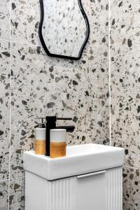 a bathroom with a white sink and a mirror at Consort 3A- 4 | Stylish Compact Studio with Kitchennette and Full Communal Kitchen in London