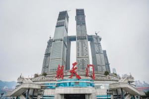 a building in front of a city with tall buildings at Pilot Hotel in Chongqing