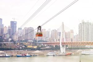 a cable car over a river with a city at Pilot Hotel in Chongqing