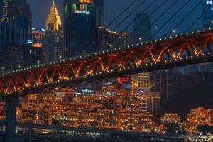 a bridge over a river with a city at night at Pilot Hotel in Chongqing