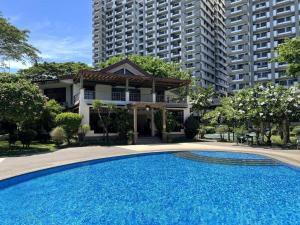 ein großer blauer Swimmingpool vor einem Gebäude in der Unterkunft Rosewood Stay Taguig Flat in Rosewood Pointe near BGC and the Airports in Manila