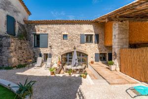 une maison en pierre avec une cour et un patio dans l'établissement La Grangerie, à Moulézan