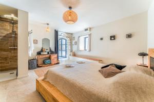 une chambre avec un grand lit et une cheminée dans l'établissement La Grangerie, à Moulézan 23 autres photos