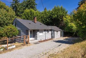 ein kleines weißes Haus inmitten von Bäumen in der Unterkunft Vintage Charm 3BR Home w Yard Pets Welcome in Shoreline