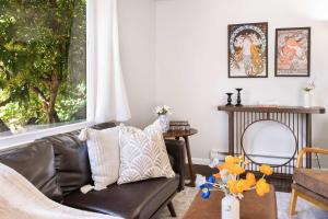 ein Wohnzimmer mit einem schwarzen Ledersofa und einem Fenster in der Unterkunft Vintage Charm 3BR Home w Yard Pets Welcome in Shoreline