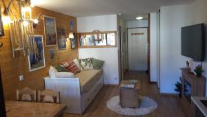 a living room with a couch and a tv at Studio Alpin & Bien-Être in Brides-les-Bains