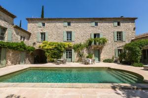 a house with a swimming pool in front of a building at Le Mas de la Chapelle in Sainte Anastasie - Aubarne