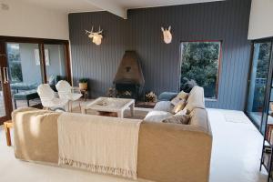 a living room with a couch and a fireplace at Rooi Els Sea Cottage in Rooiels