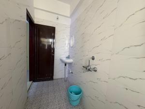 a bathroom with a sink and a toilet and a door at DXK Villa Homestay in Guwahati +37 photos
