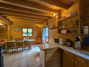 eine Küche und ein Esszimmer eines Blockhauses in der Unterkunft Chalet spacieux près de Gérardmer avec terrasse, verger et activités montagne - FR-1-589-121 in Le Tholy
