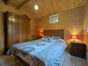 ein Schlafzimmer mit einem Bett in einer Blockhütte in der Unterkunft Chalet spacieux près de Gérardmer avec terrasse, verger et activités montagne - FR-1-589-121 in Le Tholy